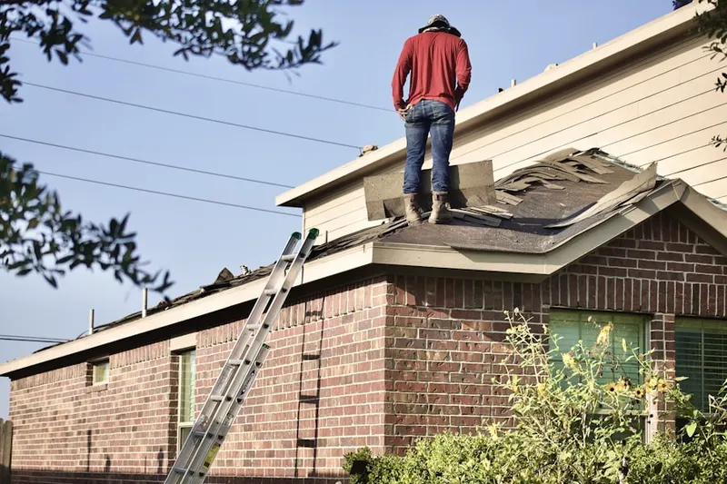Professional roofer working on a residential roof in Plandome
